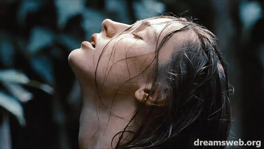A woman with long wet hair standing in soft light, representing the emotional symbolism of dreaming of wet hair.